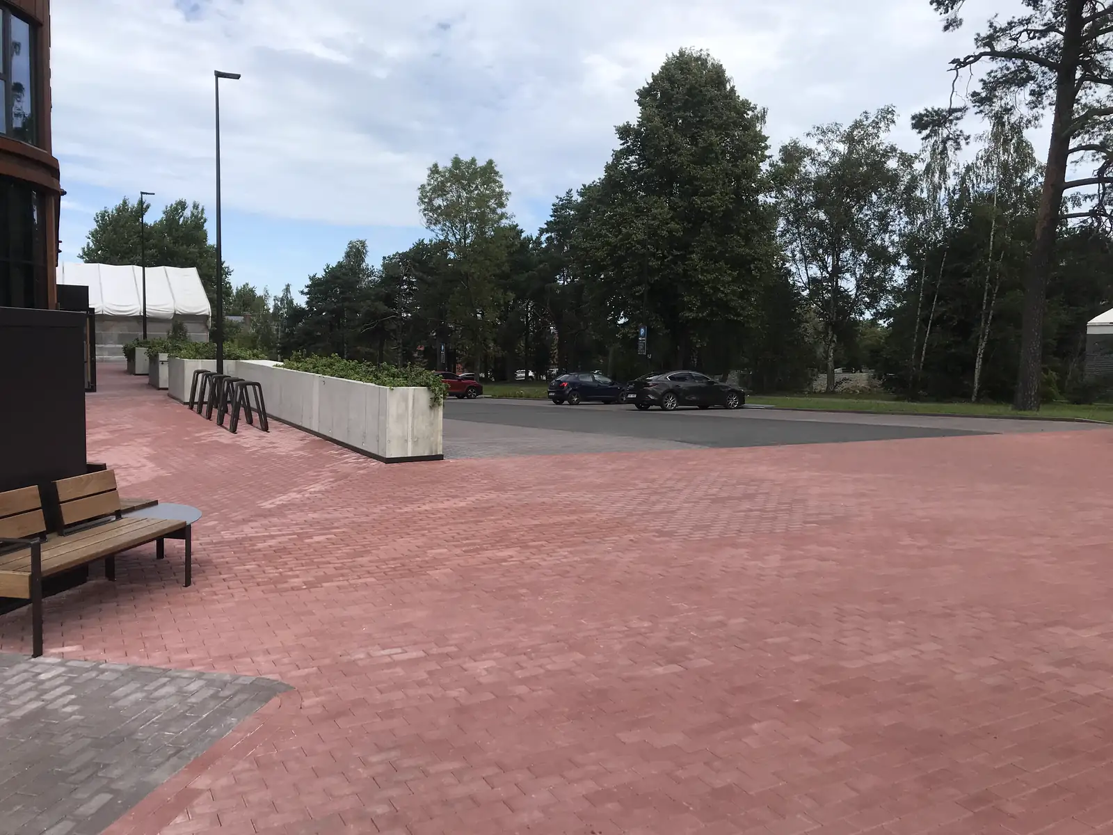 Punasest ja hallist tänavakivist sillutatud plats pinkide ja istutustega